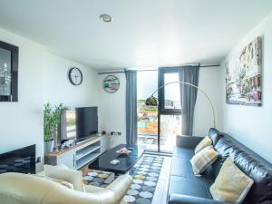 a living room with a leather couch and a tv at Exquisite 2-bedroom Apartment - City Centre in Sheffield