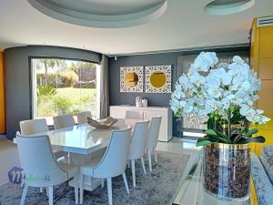 un comedor con mesa y sillas y un jarrón de flores en Villa Bonsai, en Arco da Calheta