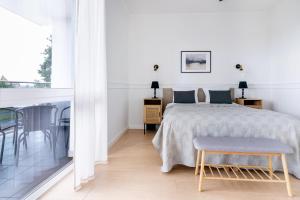a white bedroom with a bed and a table at UKIEL PARK 20 - Apartament Superior 2 sypialnie przy Plaży Miejskiej in Olsztyn