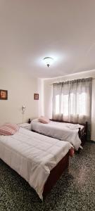 1 dormitorio con 2 camas y ventana en SOYSOL.DEPARTAMENTOS B° CIudad de Nieva en San Salvador de Jujuy