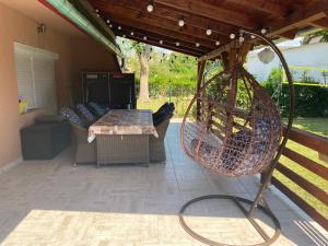 eine Terrasse mit einem Tisch und Stühlen unter einer Pergola in der Unterkunft Villa Casa Mia in Balatonlelle