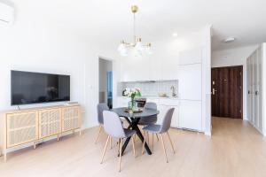 a kitchen and dining room with a table and chairs at UKIEL PARK 20 - Apartament Superior 2 sypialnie przy Plaży Miejskiej in Olsztyn
