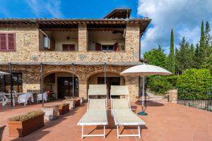 two chairs and an umbrella in front of a building at Podere Mezzastrada - Place of Charme in Fiano