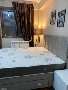 a bedroom with a large bed with a window at Italiana lux in Leskovac