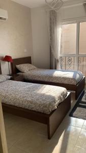 a bedroom with two beds and a window at Hayat Al-Rehab Apartment in Cairo