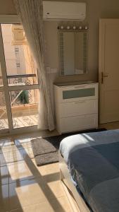 ein Schlafzimmer mit einem Bett und einem großen Spiegel in der Unterkunft Hayat Al-Rehab Apartment in Kairo