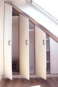 eine Reihe weißer Schränke mit Glastüren in der Unterkunft Kostengünstige & charmante Ferienunterkunft ohne Küche und in Strandnähe - Ideal für Kurztrips oder 1-Nacht Aufenthalte in Scharbeutz