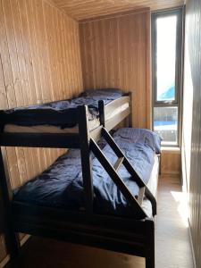 two bunk beds in a cabin with a window at New apartment, Gausta in Rjukan. Ski in/ ski out in Rjukan