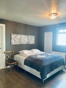 um quarto com uma cama grande e uma parede azul em Lovely Penthouse downtown with 3 bedrooms em Akureyri