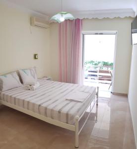 エディプソスにあるTsakalos Apartmentsのベッドルーム(大きな窓、白いベッド付)