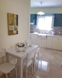 エディプソスにあるTsakalos Apartmentsのキッチン(白いテーブル、白い椅子付)