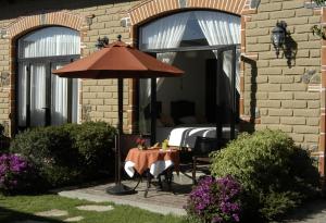 un patio con mesa y sombrilla en La Buena Vibra Retreat and Spa Hotel Adults Only en Tepoztlán