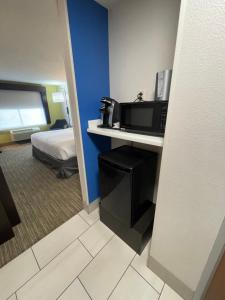 a hotel room with a bed and a microwave at Holiday Inn Express Hotel & Suites Las Vegas, an IHG Hotel in Las Vegas