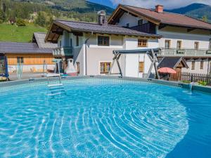 a large swimming pool in front of a house at Landhaus Hotter 18 in Neukirchen am Großvenediger