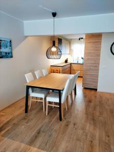 a dining room with a wooden table and white chairs at Apartment with Amazing Mountain View in Bolungarvík
