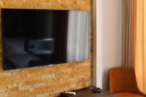 a flat screen tv hanging on a brick wall at Bella Superior Studio in Kruševac