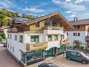 duży biały budynek z drewnianymi balkonami w obiekcie Apartment Sigi w mieście Brixen im Thale