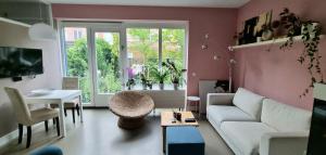 a living room with a white couch and a table at Lovely 1 bedroom apartment with garden in Amsterdam