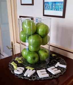 a pile of green apples in a vase on a table at Hotel Infanta Isabel by Recordis Hotels in Segovia