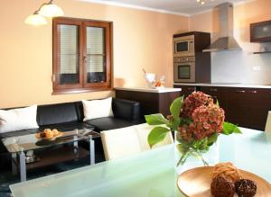 a living room with a couch and a table with flowers at Sportpenzion Pohoda in Pilsen