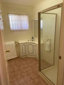 La salle de bains est pourvue d'une douche, d'un lavabo et d'un miroir. dans l'établissement The Cottage, à Mildura
