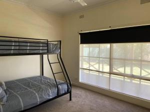 a bedroom with a bunk bed and a window at The Cottage in Mildura