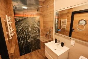 a bathroom with a sink and a mirror at Nobel 55 Apartament in Władysławowo