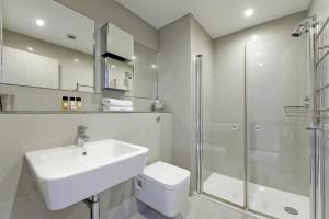 a bathroom with a sink, toilet and bathtub at Templeton Place by Supercity Aparthotels in London