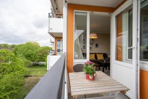 a porch with a wooden bench and a vase of flowers at Apartment Plön Seeblick in Plön
