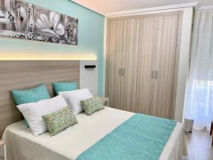 um quarto com uma cama grande e paredes azuis em Coliseo Albir Beach em Albir