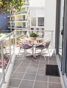 a patio area with a table and chairs at Swell Resort Burleigh Beach in Gold Coast