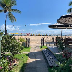 莫羅聖保羅的住宿－揮桿旅館及餐廳，一条通往海滩的小路,那里设有长凳和遮阳伞