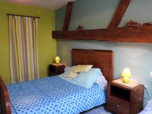 a bedroom with a blue bed with two lamps on tables at Gîte Breuvannes-en-Bassigny, 3 pièces, 5 personnes - FR-1-611-44 in Breuvannes