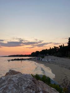 una playa con gente en el agua al atardecer en THE HOUSE WITH THE VIEW, en Nikiti