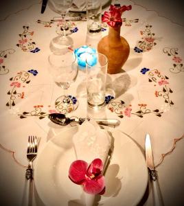 una mesa con un plato blanco con una flor. en Pousada do Sonho, en São Miguel dos Milagres