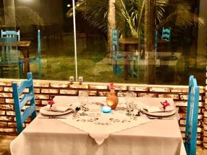 a table with a white table cloth and a vase on it at Pousada do Sonho in São Miguel dos Milagres