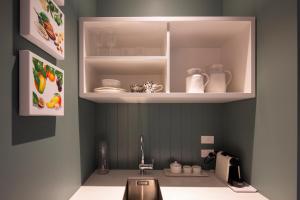 a kitchen with a sink and a cupboard with dishes at The Vicarage Geraldine in Geraldine