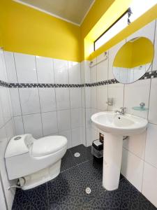 a bathroom with a white toilet and a sink at Hostal Berlin in Jauja