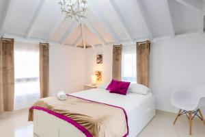 a white bedroom with a large bed and a chandelier at Ohana2 Luxury Villa in Málaga +39 photos