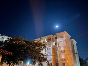 un edificio con la luna en el cielo en Apt 1D Aeroporto/Arena en Porto Alegre