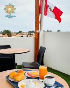 a table with breakfast food and orange juice on it at Mandala in Pisco