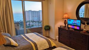 a bedroom with a bed and a television and a window at Bella Sirena 602-B in Puerto Peñasco +43 photos