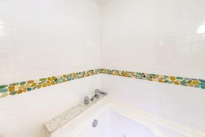 a bathroom with a bath tub with a tile border at Isle of View Too in Mexico Beach