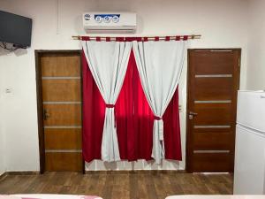 cortina roja y blanca en una habitación con dos puertas en Hospedaje La Perla en Encarnación