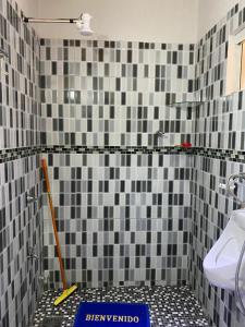 uma casa de banho com azulejos pretos e brancos no chão em Hospedaje La Perla em Encarnación