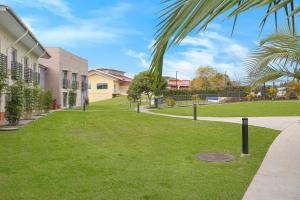a grassy area in front of a building with trees at Springs Shoalhaven Nowra in Nowra