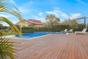 a swimming pool with two chairs on a wooden deck at Springs Shoalhaven Nowra in Nowra