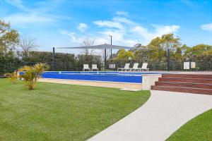 a swimming pool in a yard with chairs at Springs Shoalhaven Nowra in Nowra