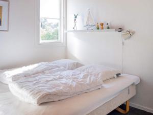 uma cama branca num quarto com uma janela em Holiday home Vestervig XXXVIII em Vestervig