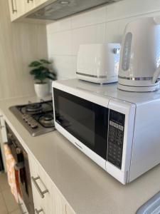 a microwave sitting on top of a kitchen counter at Modern Luxury 1 Bedroom Apartment - Walk to the shops! Free Wifi in Clarkson